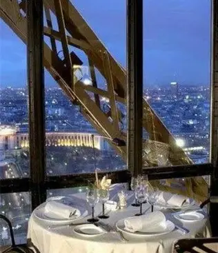 Luxurious dinner table with a view of the Paris sunset from the Eiffel Tower restaurant